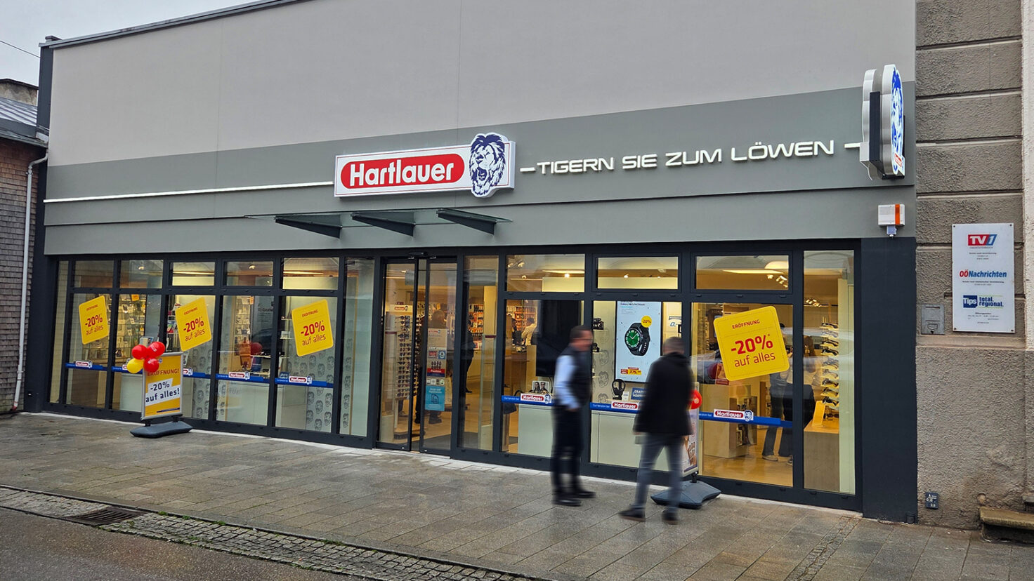Leuchtschilder und Leuchtschriften an der Fassade der Hartlauer Filiale in Grieskirchen