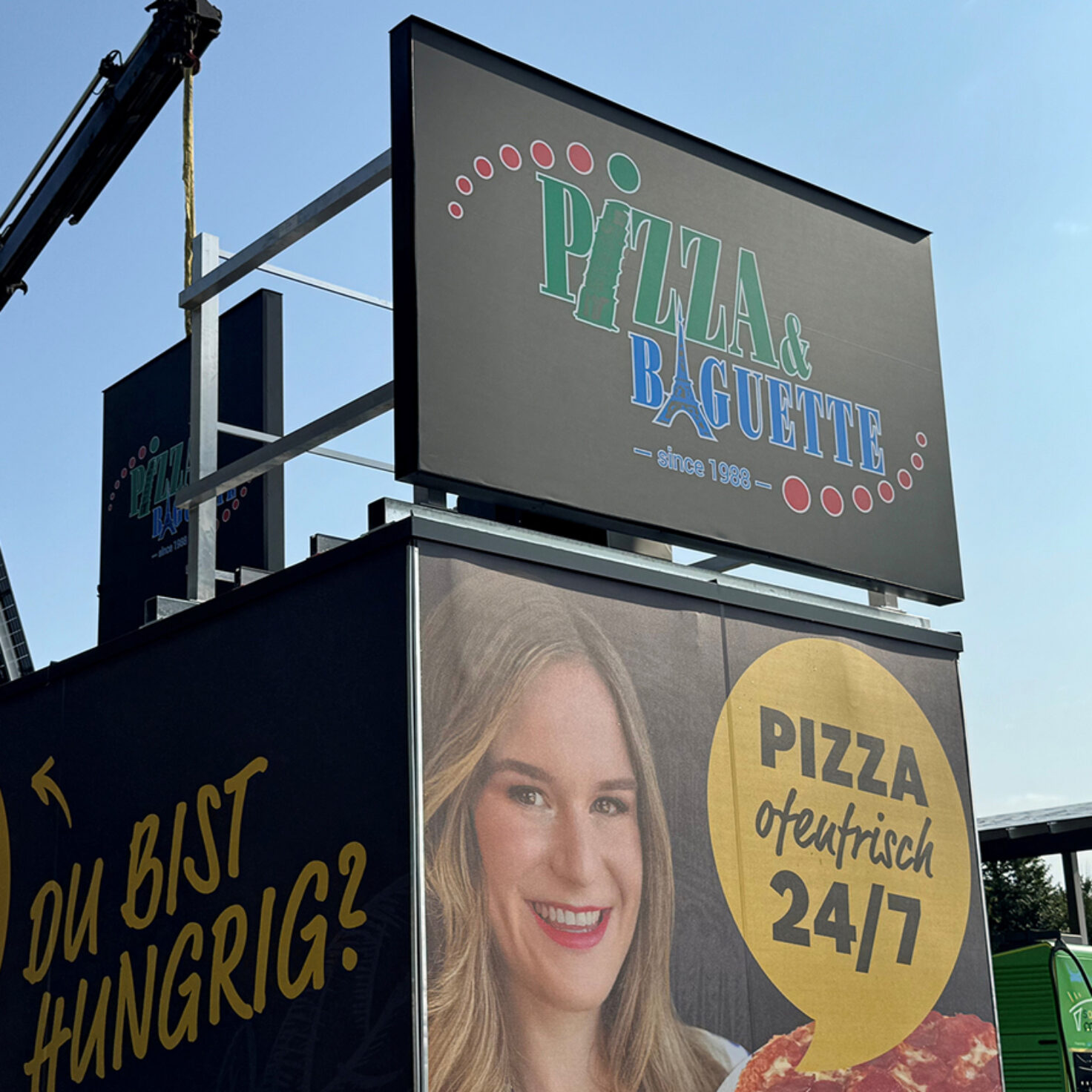 Montage der Leuchtschilder am Dach eines Containers der Pizza-Baguette GmbH