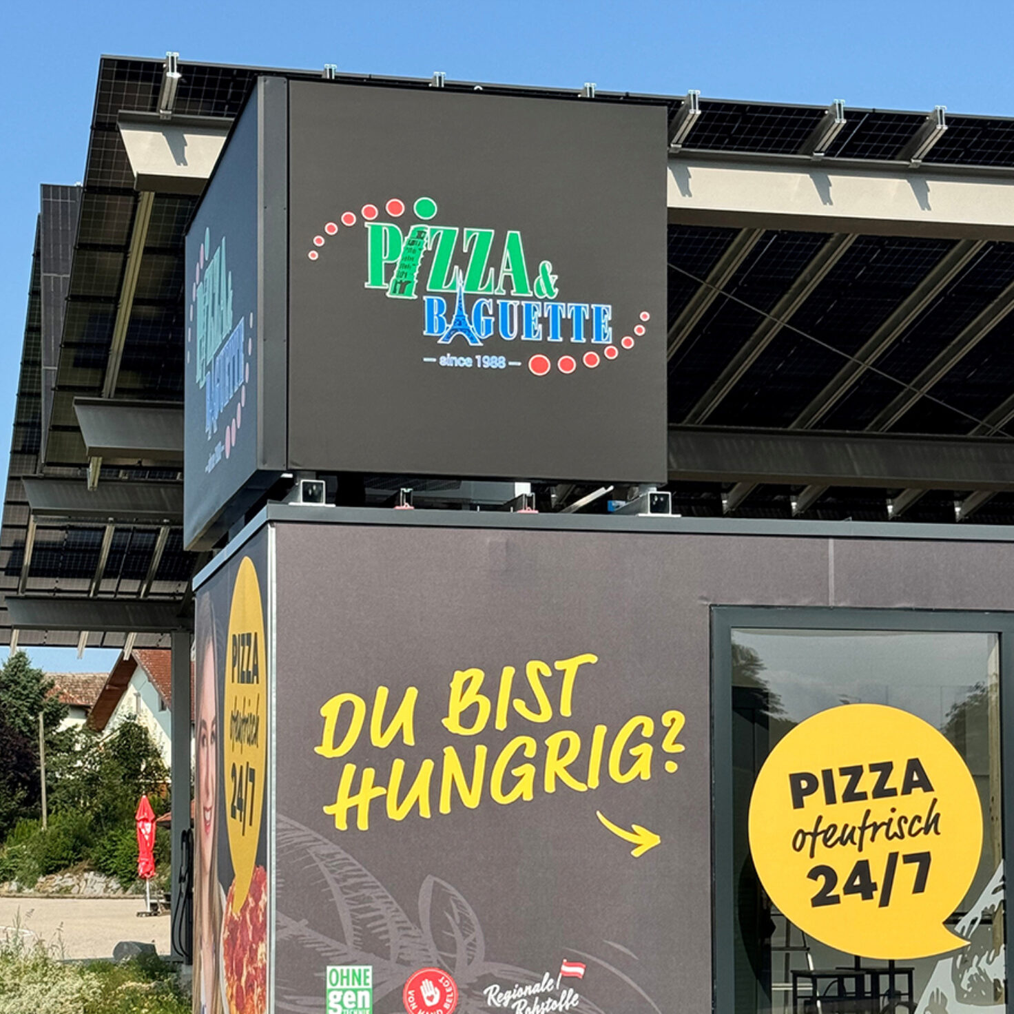 Leuchtschilder am Dach eines Containers der Pizza-Baguette GmbH